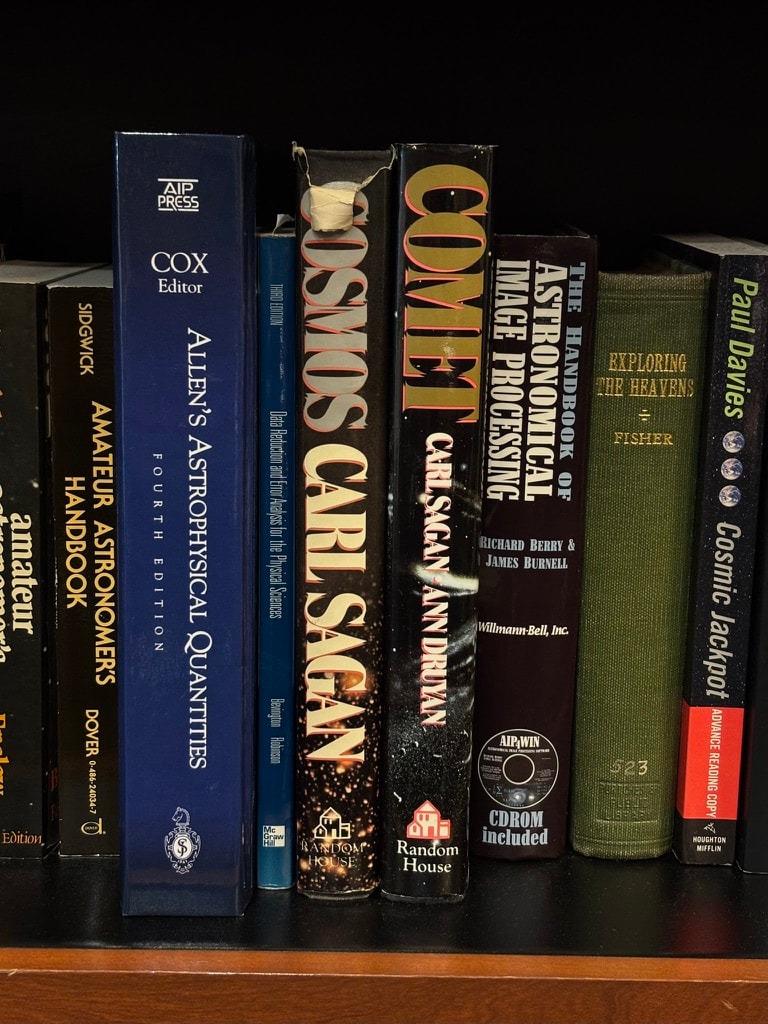 Astronomy books on a wooden shelf