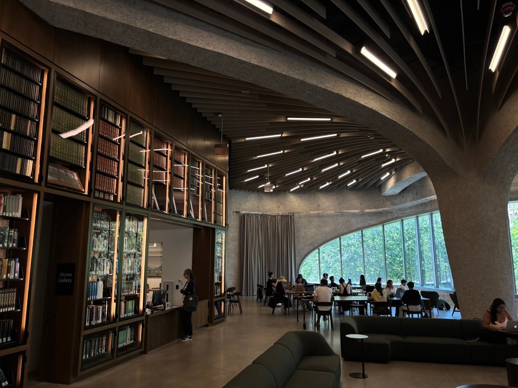 A reading room with curved concrete beams and tall windows