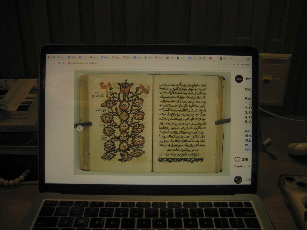 An illuminated manuscript viewed on a laptop