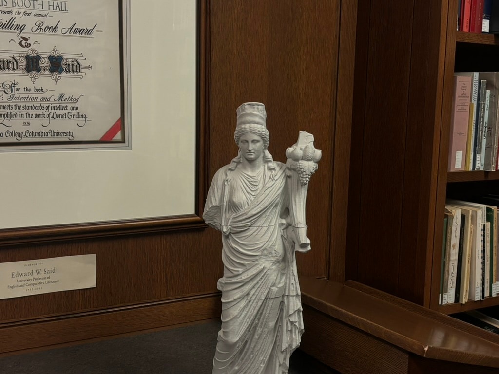 A classical statue beside books and the Lionel Trilling Book Award